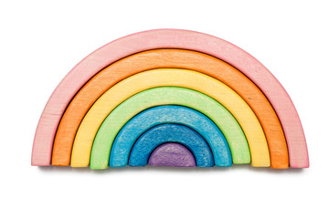 Wooden puzzle in the form of a rainbow isolated on white. Multicolored toy.
