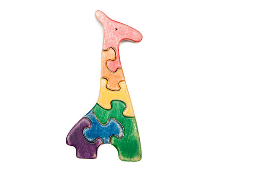 Wooden puzzle a giraffe isolated on white. Multicolored toys.