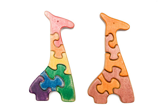 Wooden puzzle two giraffes isolated on white. Multicolored toys.