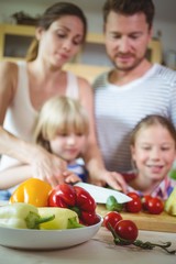 Family chopping vegetables in the kitchen