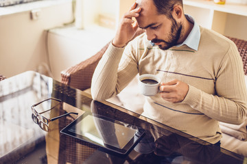 Casual Man Using Tablet Computer Sitting in Cafe Surfing Internet