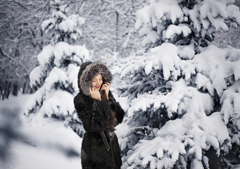 Девушка стоит в зимнем парке 