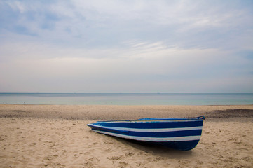 Naklejka premium Лодка на берегу красивого моря.