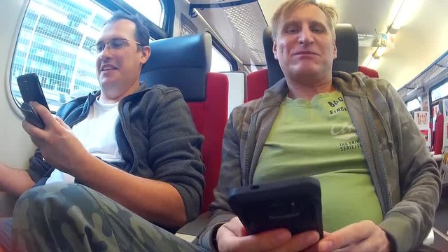 Moscow, Russia - October 5, 2016: Two middle-aged men riding on a train and talking