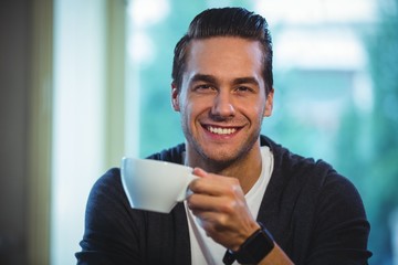 Handsome man having a cup of coffee in café