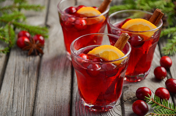 Cranberry drink on wooden background with fir branches and fresh berries, selective focus