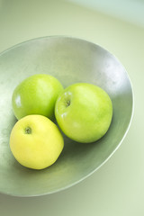 Three green apples on dish