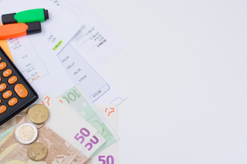 Utility or mortgage bills, calculator and Euro banknote and coins copy space