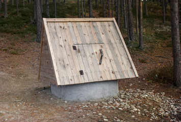 Well on a background of pine forest