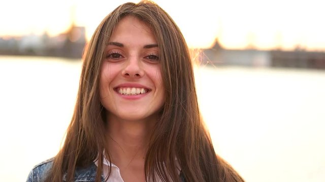 Girl smiling on the city waterfront.