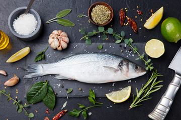 Raw fish, sea bass on slate black board Top view