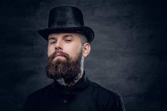 Bearded male with tattoo on his neck and top hat cylinder on hea