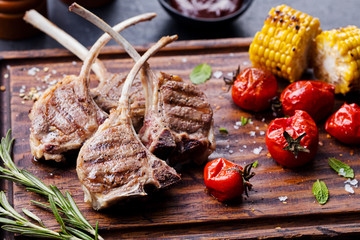 Lamb ribs grilled on cutting board with vegetables - obrazy, fototapety, plakaty