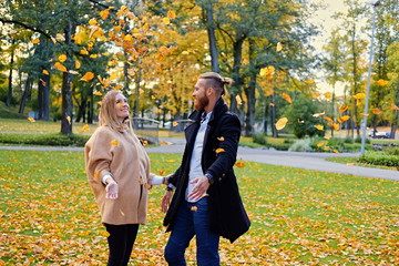 Obraz premium Redhead male and blonde female having fun in autumn city park.