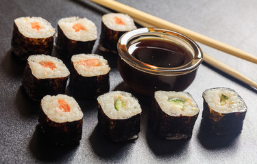 Sushi rolls on a black surface