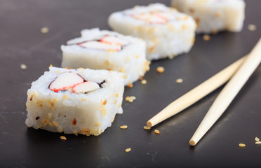 Sushi rolls on a black surface