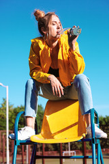 beautiful cheeky girl with bottle water on sports field
