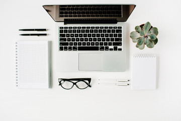 Flat lay, top view office table desk. Workspace with laptop, diary, succulent and glasses on white...