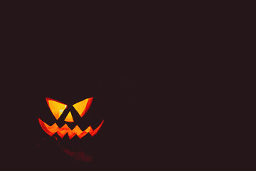 Glowing pumpkin symbolizing the head of old Jack on night spooky dark background. Soft focus. shallow DOF