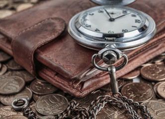 Fototapeta premium Wallet and pocket watch on the coins background