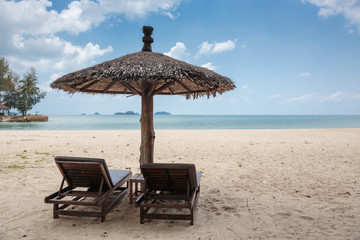 Two lounge chairs and a sunshade umbrella on the beach
