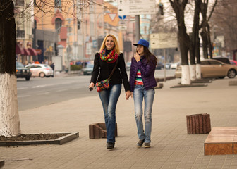 Mother and daughter walking in the city