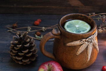 Obraz na płótnie Canvas hot herbal tea with lemon and apple on a wooden background