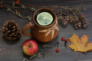 hot herbal tea with lemon and apple on a wooden background