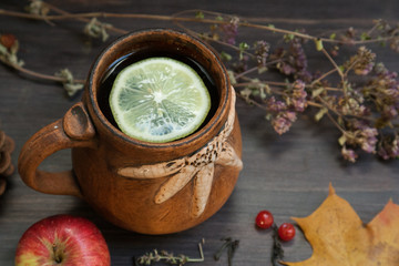 hot herbal tea with lemon and apple on a wooden background