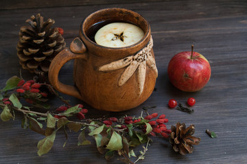 hot herbal tea with lemon and apple on a wooden background