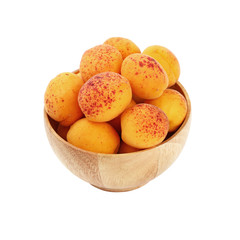 Ripe fresh apricots in wooden bowl over white