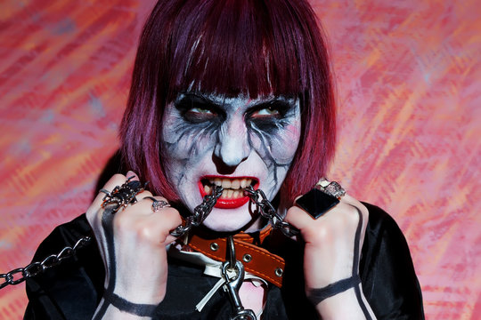 girl with makeup zobi with metal chain in his mouth