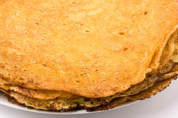thin pancakes on a white plate closeup