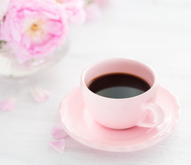 Still life with cup of coffee and  bouquet of roses. Selective focus. Shallow depth of field.