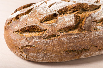 Loaf of rye bread on wooden table