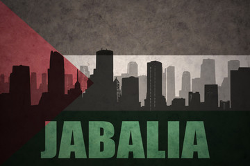 abstract silhouette of the city with text Jabalia at the vintage palestinian flag background