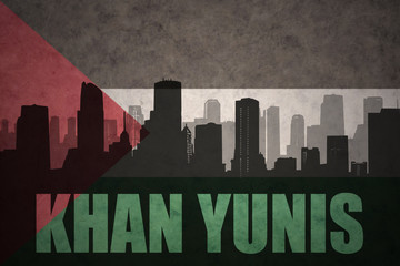 abstract silhouette of the city with text Khan Yunis at the vintage palestinian flag background