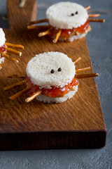 Spooky peanut butter and jelly sandwiches spiders for halloween on a cutting board