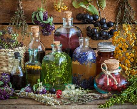 Bottles of tincture, potion, oil, healthy berries and herbs