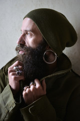 Portrait of an pierced man with earrings and beard