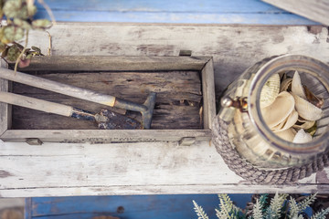 Vintage style decoration accessories in rustic Provence style on aged wooden table with old glass jar and sea shells