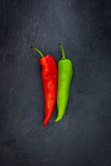 Red and green peper on a gray slate