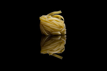 Nest pasta isolated on black reflective background
