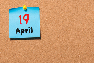 April 19th. Day 19 of month, calendar on cork notice board, business background. Spring time, empty space for text