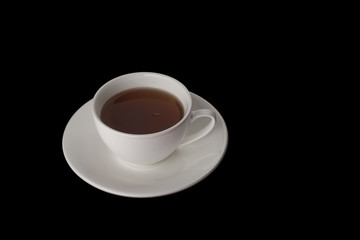 White Cup with saucer on black background. A Cup of tea. White ceramic kitchenware. For design. Studio light.