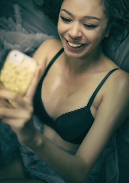 Young woman smiling laughing holding using her smart phone.