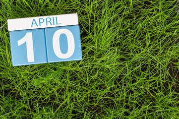 April 10th. Day 10 of month, calendar on football green grass background. Spring time, empty space for text