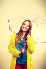 Woman wearing waterproof coat under umbrella