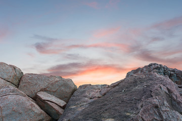 Pile of rocks boulders on sunset sky background