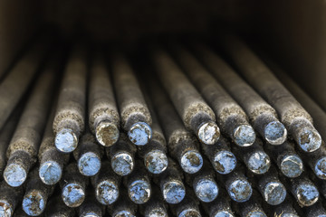 Closeup of a box of welding rods taken end on. Blue and white marking on end of rods.